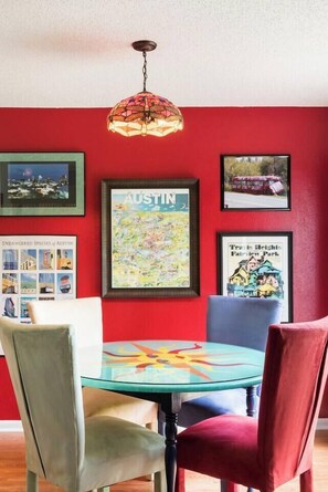 Gather around the hand-painted dining table in the bold, cherry-red dining space.