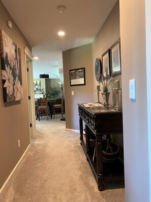 Hallway leaving bedrooms, w/dinette and living room areas in backdrop.