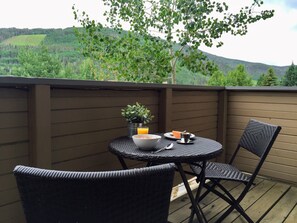 Table w/ 2 chairs for relaxing on the balcony during nice weather.