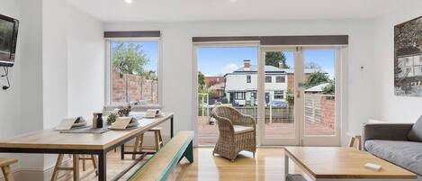 The open-plan dining area, flooded with natural light, offers a stylish and comfortable space to enjoy meals.