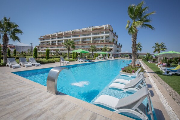 Gorgeous 40 metre swimming pool with bar, palm trees, deck chairs and parasols