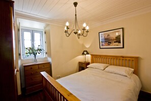 Bedroom of apartment 2 with King sized bed and matching pine furniture.