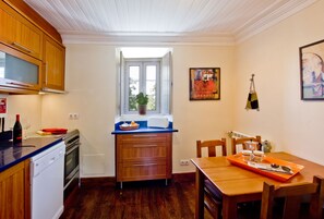 Part view of kitchen in apartment 2 featuring stripped floors & feature ceiling.
