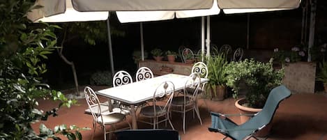 Giardino illuminato con ombrellone,tavolo e sedie 