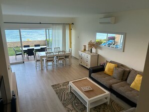 Lounge with comfy L-shaped sofa.   Indoor dining table by the sliding doors