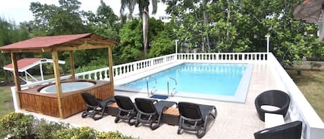 Swimming pool with Jacuzzi also BBQ pit on the ground to the left of the pool 