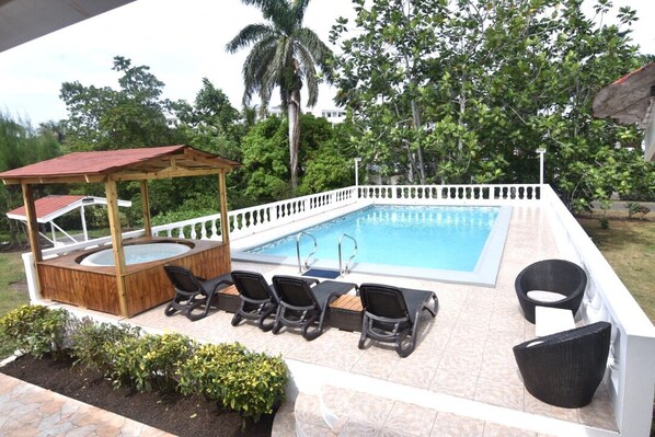 Swimming pool with Jacuzzi also BBQ pit on the ground to the left of the pool 