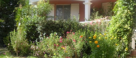 VUE du parc sur l'appartement et sa TERRASSE côté sud ; parterre de fleurs l'été