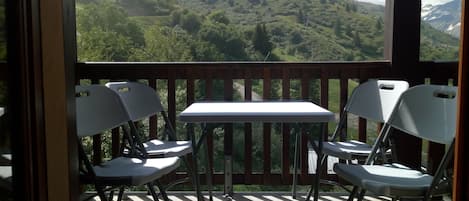 Terrasse avec table et chaises pour déjeuner et apprécier la vue.