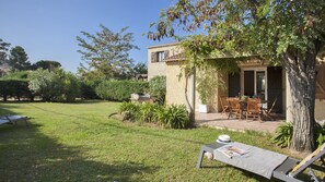 Terrasse, Pergola mit Barbecue, und privater Garten  blumig mit Liegestühlen.