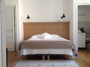 LE LIT ET LE COIN KITCHENETTE À DROITE