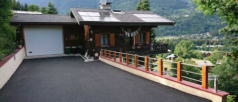 Vue d'ensemble du chalet avec son entrée agrandie (2018) et parking privatif.