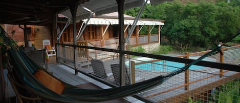 La piscine et les chambres vues depuis la terrasse du séjour.