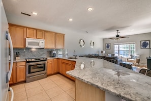 Large fully stocked kitchen with granite counters and breakfast bar