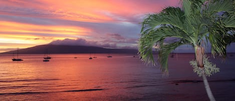 Sunset from your own private lanai, overlooking the ocean and moored boats.