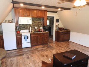 Kitchenette with electric stove/oven, microwave, and refrigerator.