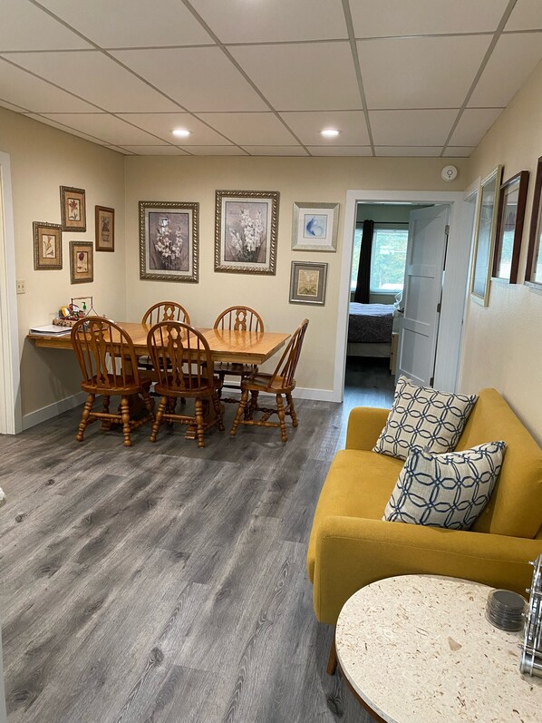 Common room with dining table, and small settee.  The kitchen is on the left. 