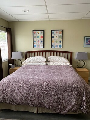 Bedroom 1, with king bed and three windows on the left.  