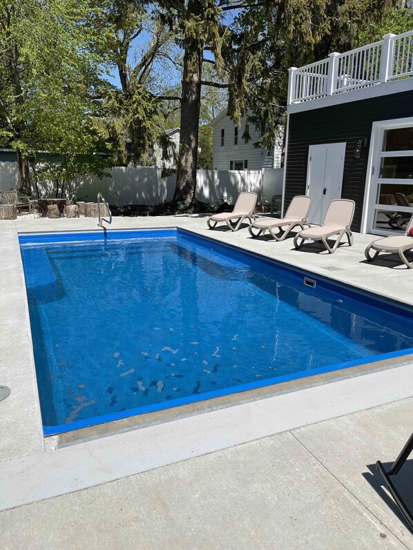 Pool with auto cover open looking toward poolhouse