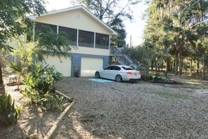 Late afternoon view of front of house from corner of yard.