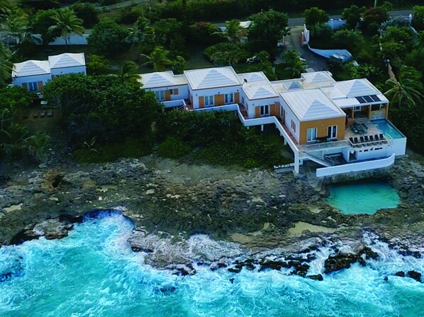 Aerial view of the main villa and cottage located on a large private lot