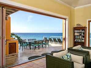 Living room that opens up to the large pool deck and outdoor kitchen