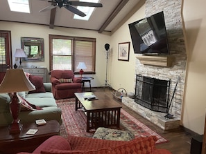 Living room with wood burning fireplace and flat screen TV