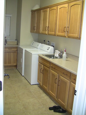 Laundry Room with Washer, Dryer, fold Down Ironing Board and Iron, & sink.