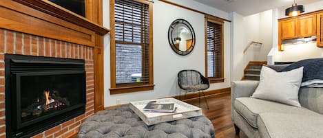 Main downstairs living space with fireplace and tv.