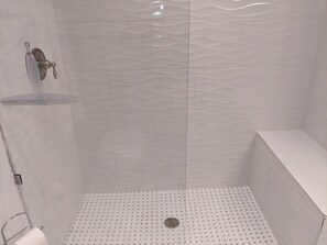 master en-suite with glass shower door and shower bench