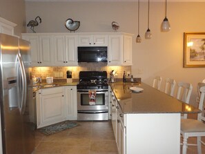 Stainless steel appliances with quartz countertops and serving bar