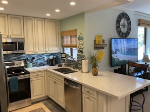 Remodeled kitchen as of 2020 and large smart TV.