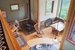 view from ;loft looking down on dining room, wood stove and kitchen.Views abound