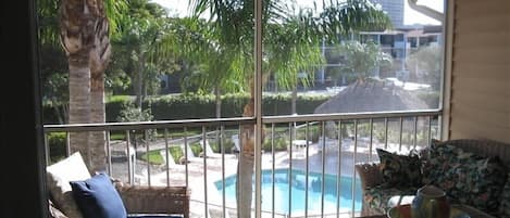 View of Pool Area from Screened Lanai which has Comfortable and Spacious Seating