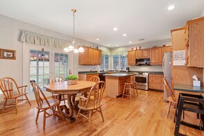 Kitchen with dishwasher, oven, microwave and restaurant-style high chair.