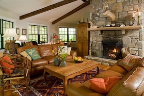 Lakehouse Great Room Features Massive Stone Fireplace and Beamed Ceiling