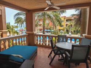 Patio with double lounger and view of the pool and the ocean