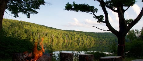 A private fire pit has stump seating for 12 people overlooking the lake.