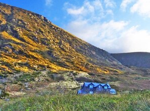 Image of the house with the mountain looming behind.