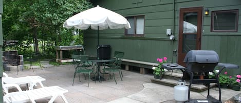 Cozy patio with fire pit, grill, umbrella table, loungers, fish cleaning table.