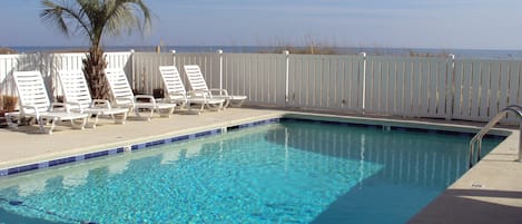 ocean side pool with lounge chairs