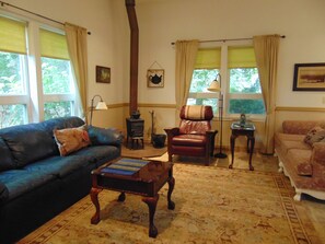 Living room with sleeper sofa, Morris chair, additional sofa, and cozy woodstove