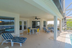 Pool deck with outside table and lounge chairs.