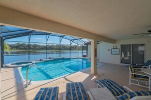 Pool deck with outside table and lounge chair. View of the lake.