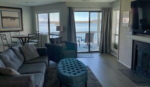 Smart TV with comfortable seating and expansive lake view.
