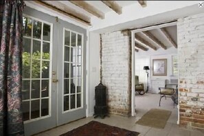 Entry of Quarters looking into bedroom, king bed. Cypress beams on ceiling.