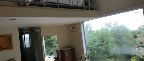 master bedroom with big wall of glass with mountain views