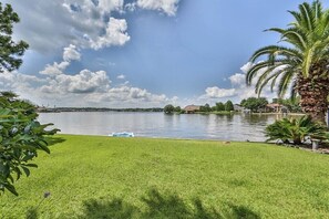 View from grassy backyard that is fully fenced for privacy.