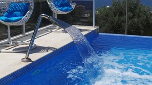 Infinity pool with jet fountain and hanging basket seats