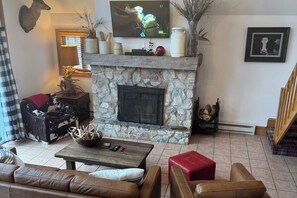 Family Room with Stone Fireplace and Sliding Glass Door that leads to deck